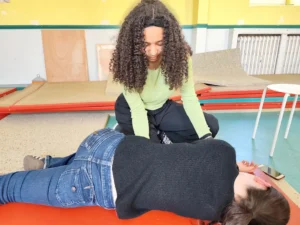 Une adolescente réalise une Position Latérale de Sécurité (PLS) sur une victime lors d'un atelier de premiers secours animé par La Brigade du Cœur.
