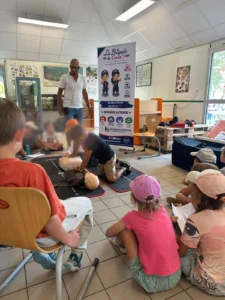 Un enfant apprend le massage cardiaque avec La Brigade du Cœur à Port-Barbe près de Nantes