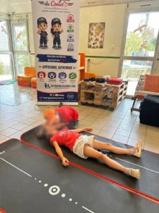 Un enfant vérifie la respiration d’une victime lors du stage Courir et secourir à Port-Barbe